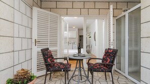 A small patio area with two wicker chairs, a round table, and a potted plant. - House Apartments Ariva (Dubrovnik)