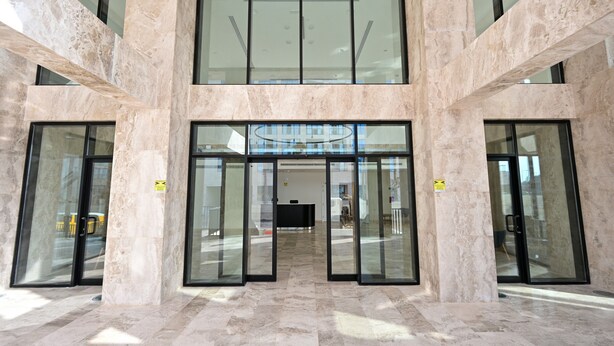 A lobby with marble flooring, large glass doors, and a modern ceiling design. - Terminal Inn By Edar City Center (Doha)