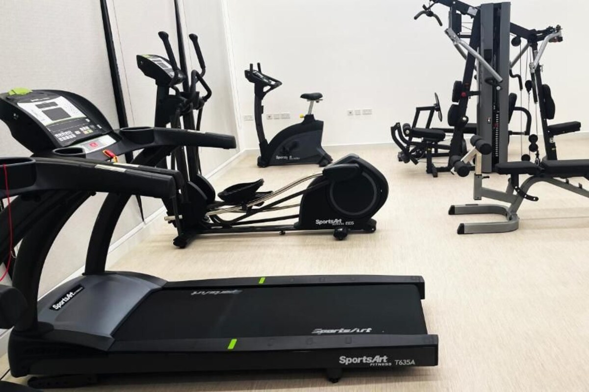 Academia com equipamentos de cardio, incluindo esteira, bicicleta ergométrica e elíptico.