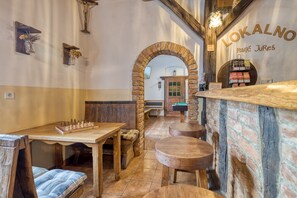 A cozy interior with a wooden table, chairs, and a brick wall. - Family Friendly France's Lair (Ljutomer)
