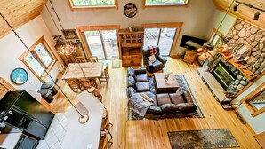 A spacious living area with a fireplace, a dining table, and a kitchen area.