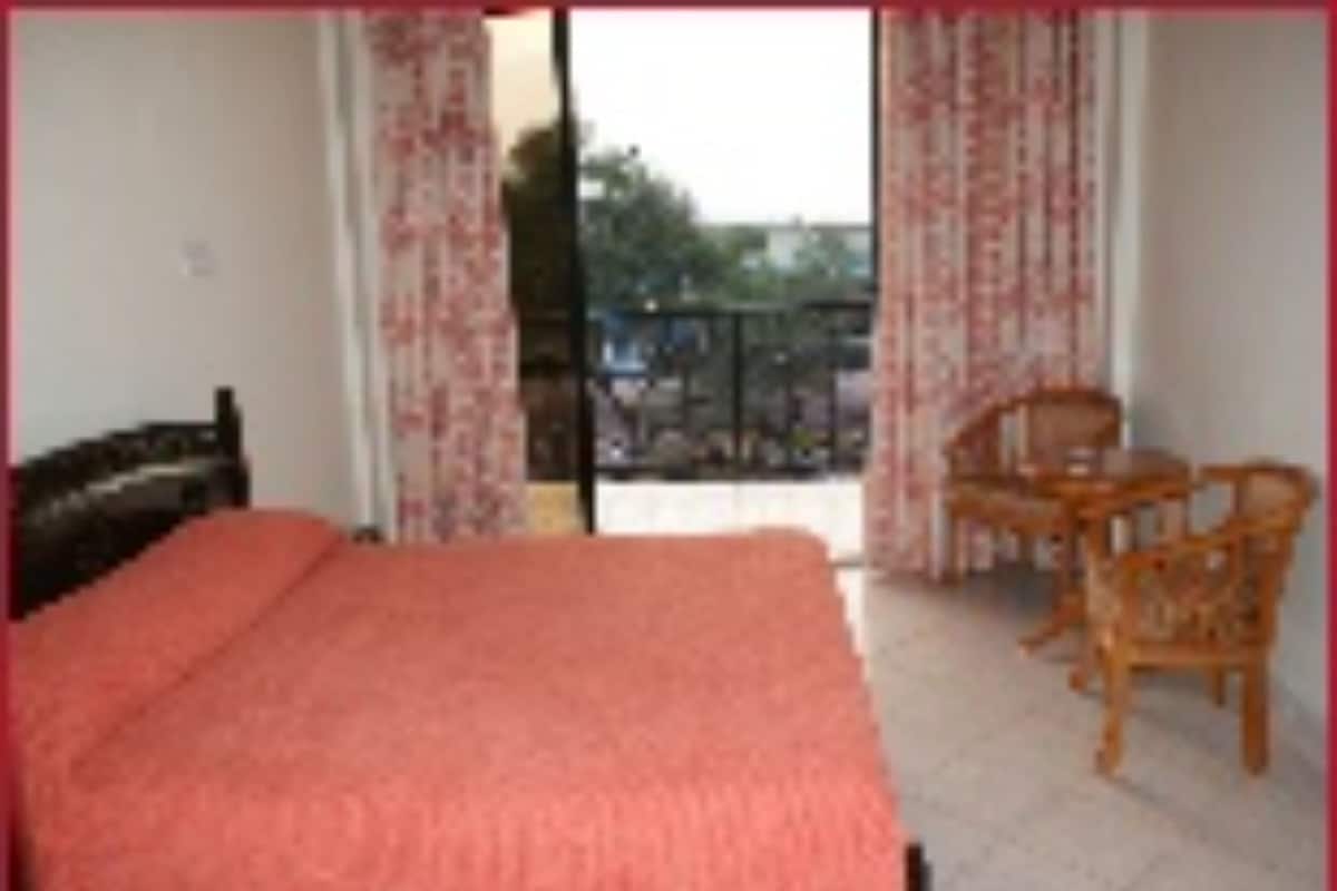 Un dormitorio con una cama, una silla y una mesa.