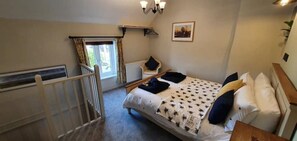 Cozy retreat with a large bed, picture window, and comfortable chair.