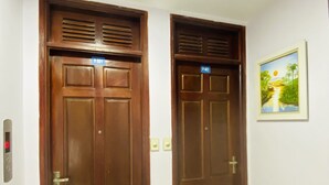 Zwei Holztüren mit digitalem Schloss und Lichtschalter an der Wand.