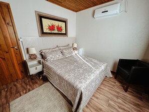 Cozy retreat with a central bed, bedside tables, and a framed artwork.