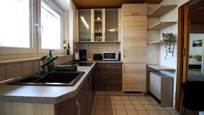 Cocina compacta con lavamanos, microondas y armarios.