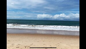 A beach with a sandy shore and waves approaching. - House with pool on the best beach in Itacimirim! (camaçari)
