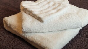 A folded white towel on a dark surface.