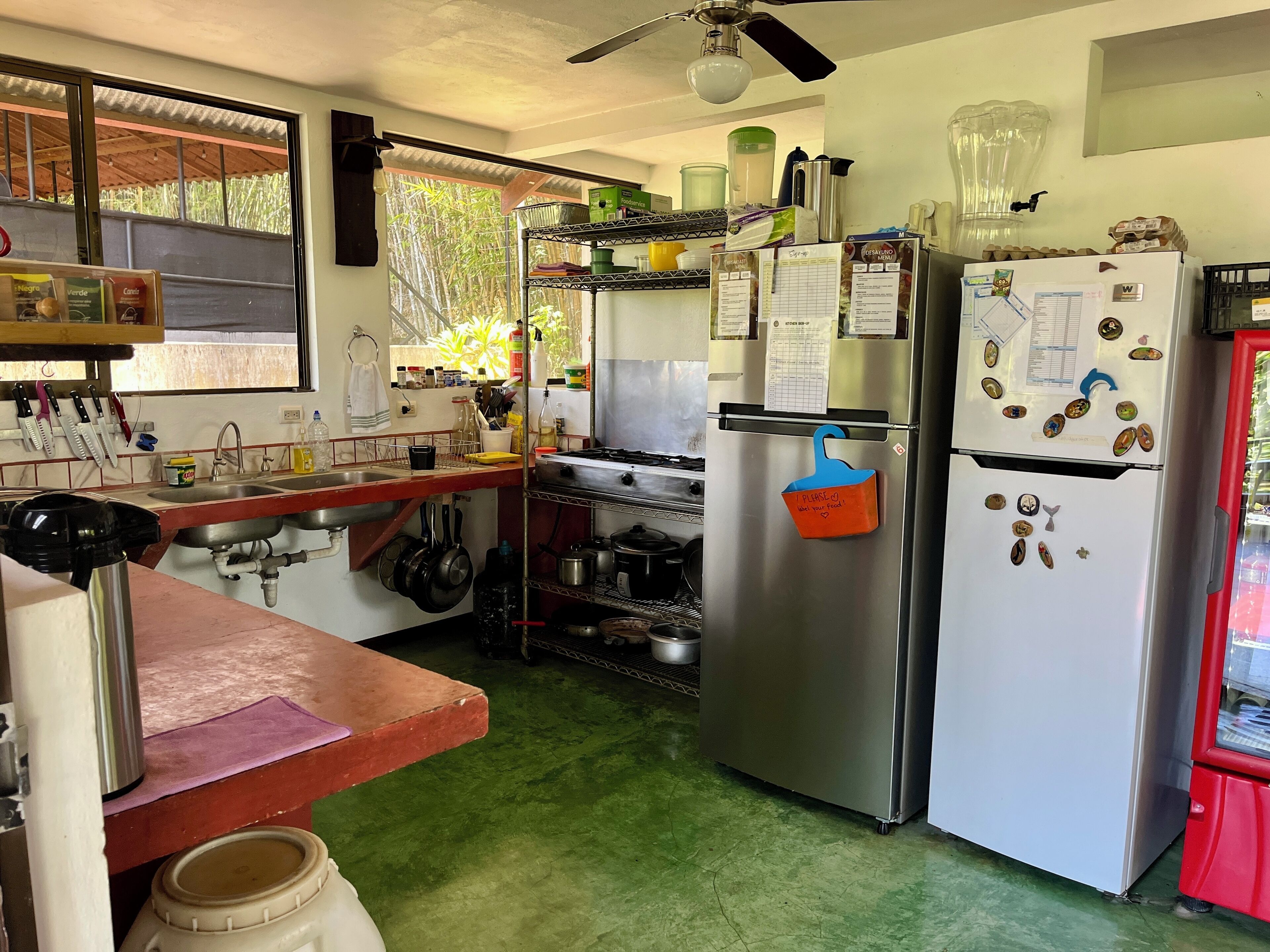 A kitchen with stainless steel appliances, a sink, and various kitchen utensils.