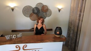 A reception desk with a sign reading "CALA CORSA" and a decorative wall with circular patterns.