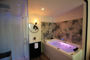A modern bathroom with a freestanding bathtub, a glass shower enclosure, a vanity with a mirror, and a floral wall mural. - La Maison de l'Olivier (Avignon)