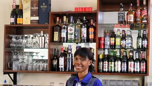 A bar area with various liquor bottles and glasses. - La Rochelle hôtel (Yaoundé)