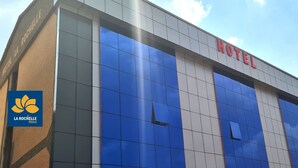 A hotel facade with a blue and white color scheme, featuring the name 'HOTEL' prominently displayed. - La Rochelle hôtel (Yaoundé)