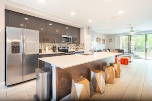 Enjoy cooking in this well-lit kitchen with a central island and stainless steel refrigerator.