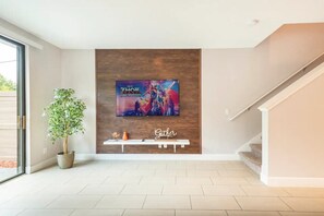 Relax in a welcoming space with a large flat-screen TV and comfortable seating area.