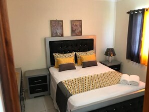 Comfortable retreat with a neatly made bed, nightstand, and framed artwork.