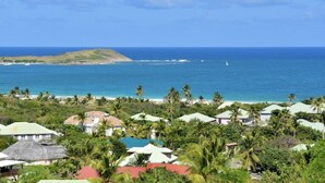 A coastal resort with multiple bungalow-style buildings, a beach, and a clear view of the ocean. - SUNSEEKER SXM (Marigot)