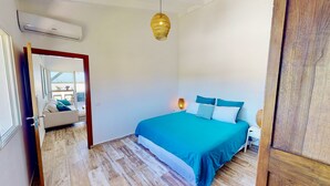A bedroom with a bed, a bedside lamp, and a hanging light fixture. - SUNSEEKER SXM (Marigot)