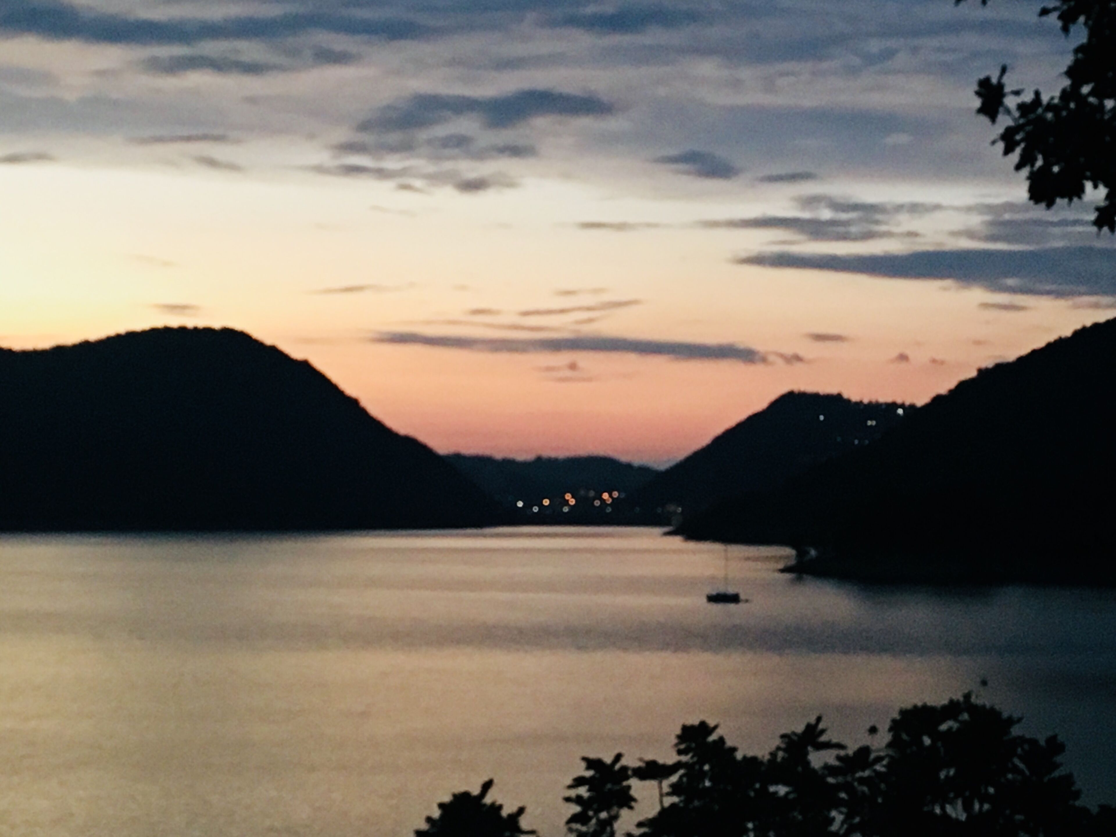 Un lago tranquillo circondato da colline al crepuscolo.