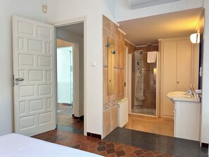 A bathroom with a shower, a sink, and a toilet.