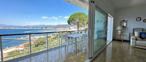A balcony with a view of the sea and a tiled floor.
