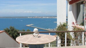 Un balcón con vistas al mar y una estatua de un niño.