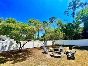 Relax in a serene outdoor space surrounded by lush greenery and a cozy fire pit.