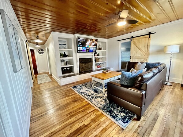 Cozy living room with a fireplace, leather sofa, and TV.