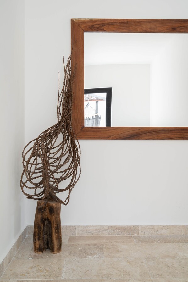 A wooden sculpture with a mirror reflecting a building.