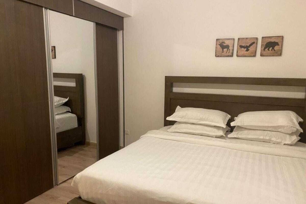 Une chambre à coucher comprenant un lit, une armoire et trois décorations murales sur le thème des animaux.