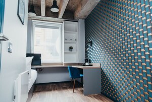 Un espacio de oficina moderno con escritorio, silla y estantería.