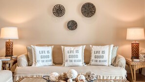 A cozy bedroom with a bed, two bedside lamps, and decorative pillows with a beach theme. - Way Down in Kokomo (St. Augustine)