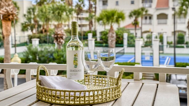 A bottle of Seaglass Pinot Grigio Central Coast 2021 on a table with two glasses. - Way Down in Kokomo (St. Augustine)