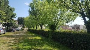 A residential street lined with trees and parked cars. - Casa Marisa (Toscolano Maderno)