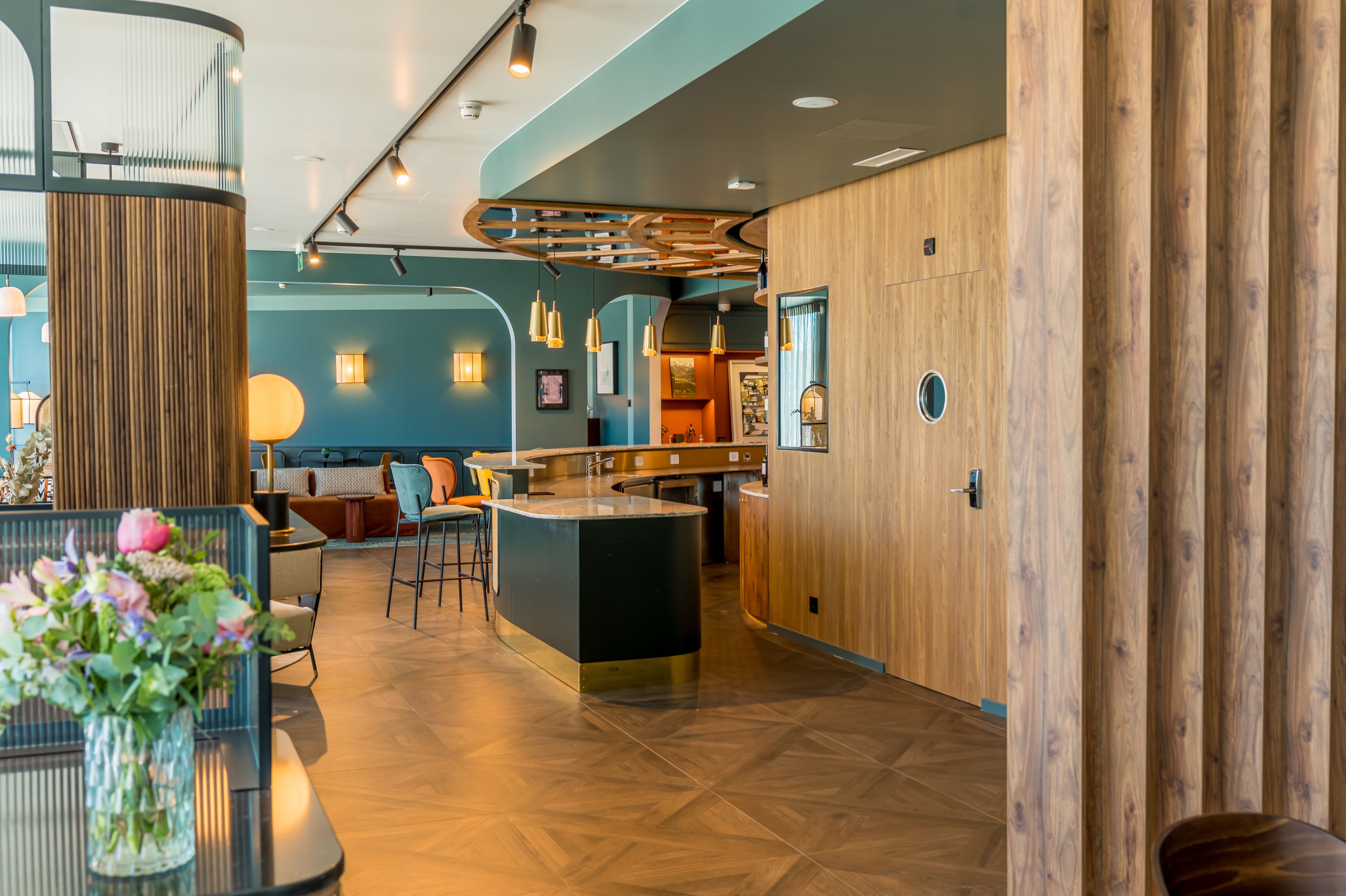 A modern interior with a bar area, seating, and a wooden accent wall.