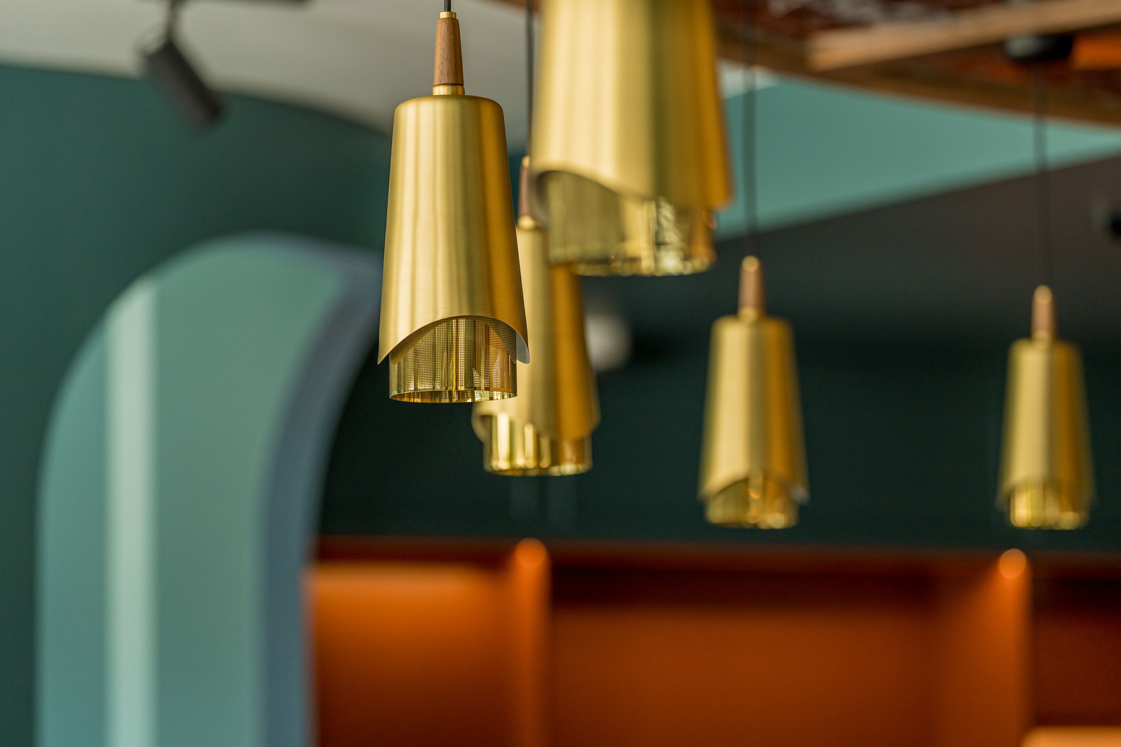 A close-up of a ceiling with multiple golden pendant lights.