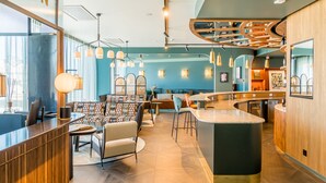 Un interior moderno con una zona de bar, asientos y una barra.