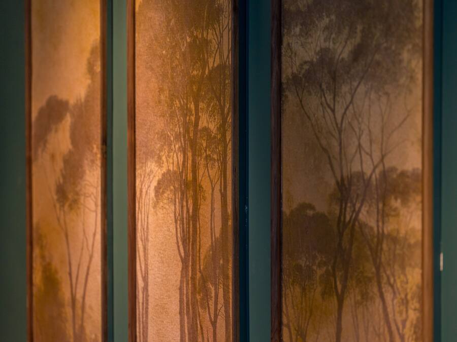 A wall with vertical panels displaying tree silhouettes.