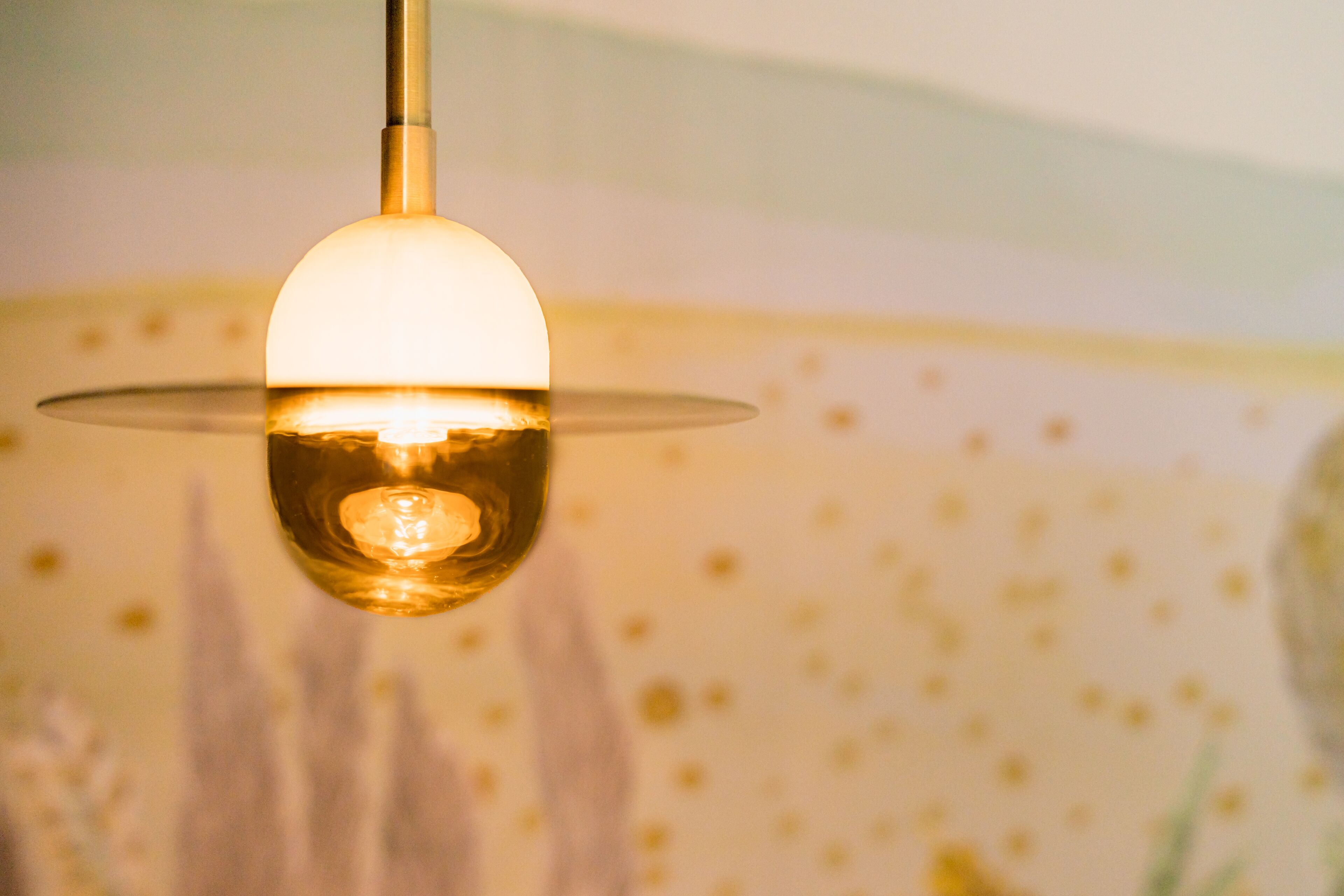 A pendant light fixture with a clear glass shade and a visible bulb.