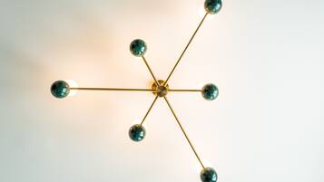 A ceiling light fixture with a central hub and multiple arms extending outward, each ending in a spherical bulb.