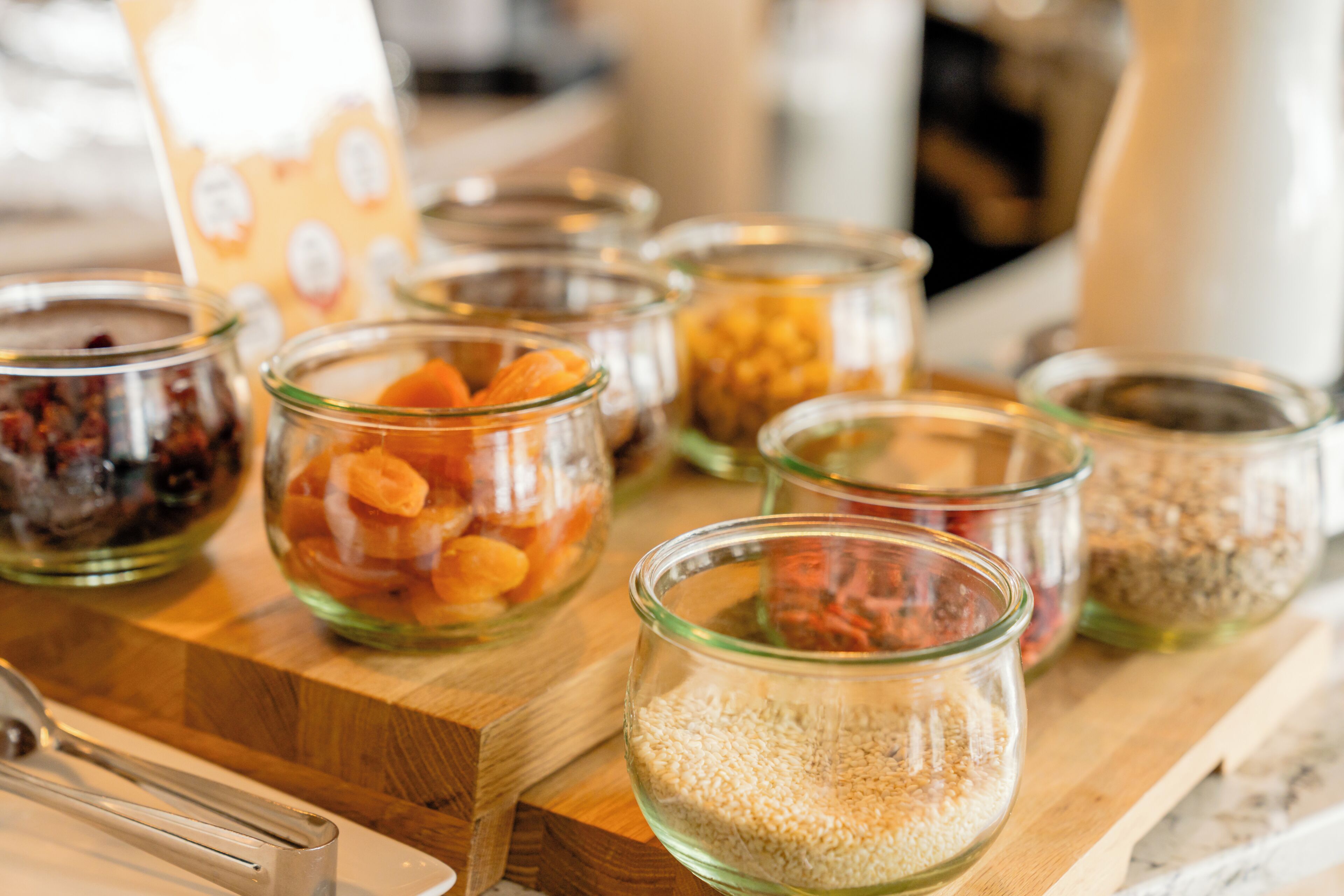 A wooden board with several glass jars containing various food items.