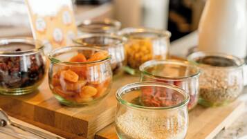A wooden board with several glass jars containing various food items.