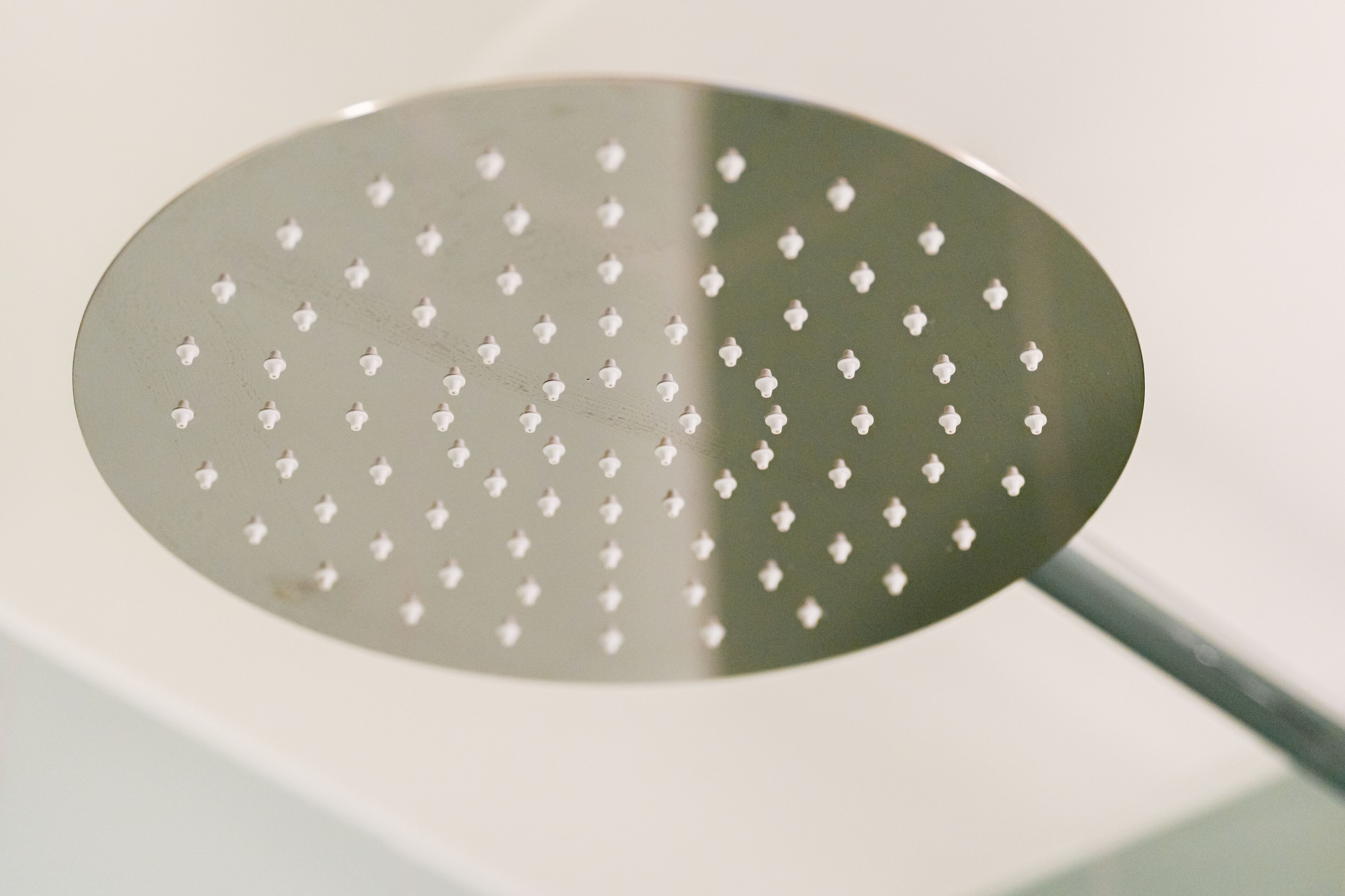 A close-up of a metallic object with a perforated surface and a handle.