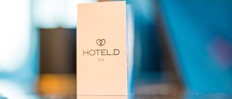 Une brochure de l’hôtel D, avec un logo en forme de cœur et le mot « Bulle » imprimé dessus.