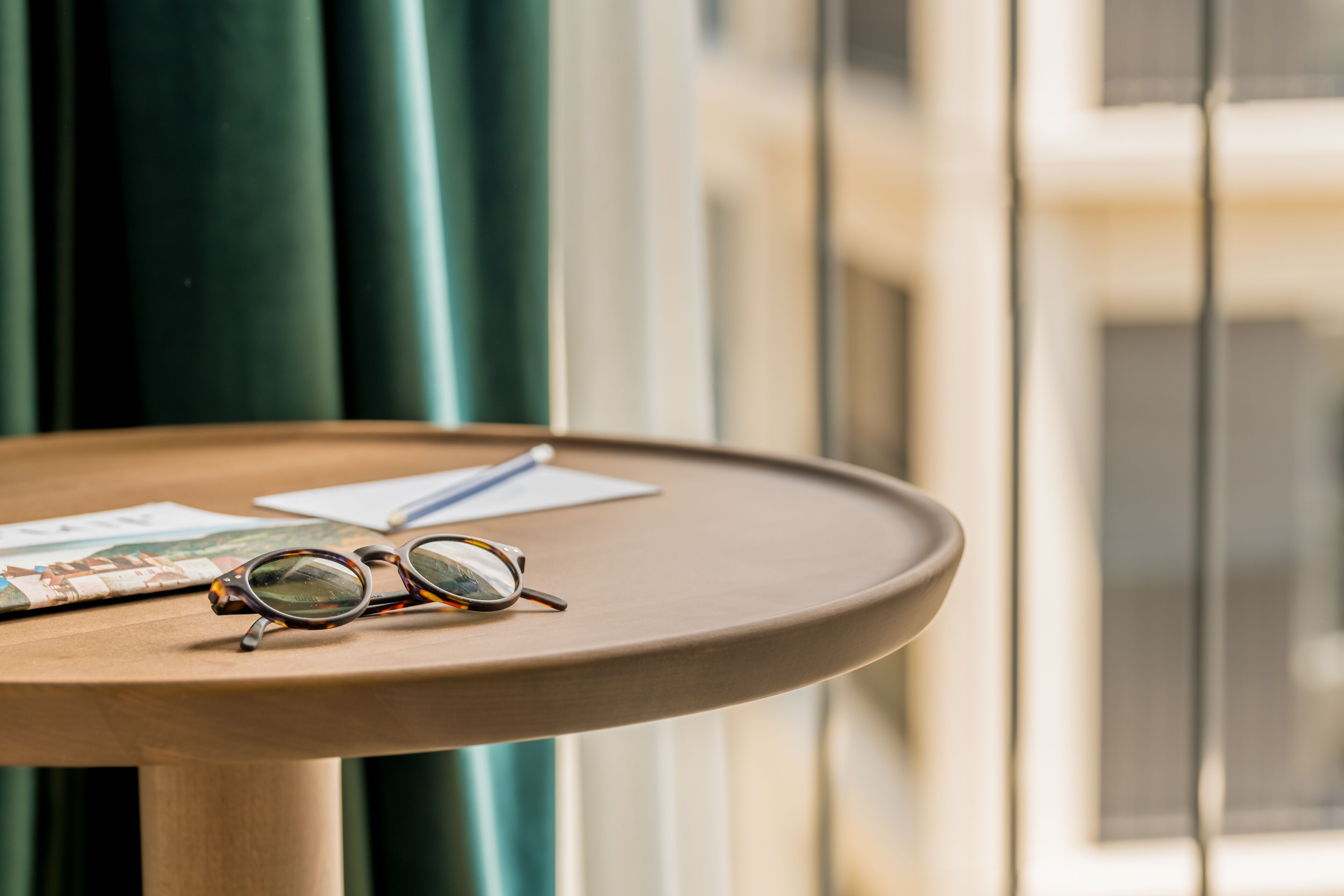 Une table ronde avec une paire de lunettes et un petit livre.