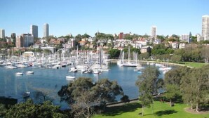 A marina with numerous boats docked, surrounded by residential buildings and greenery.