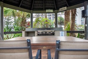 Enjoy al fresco dining in a serene garden setting, complete with a grill and seating area.