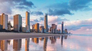 A beachfront cityscape with high-rise buildings, a sandy beach, and a calm sea. - Surfers Paradise Beachfront Pool and Views (Surfers Paradise)