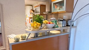 Une cuisine moderne avec un îlot central, un four à micro-ondes placé au-dessus et un lampadaire.