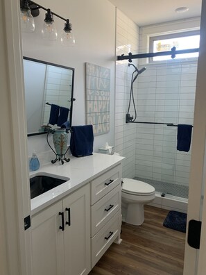 Een douche, handdoeken, zeep, toiletpapier